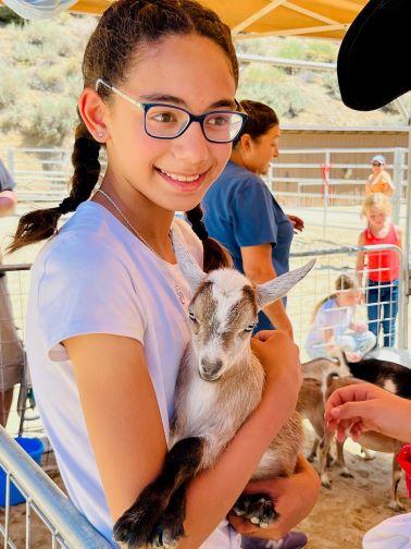 girl holding baby goat 